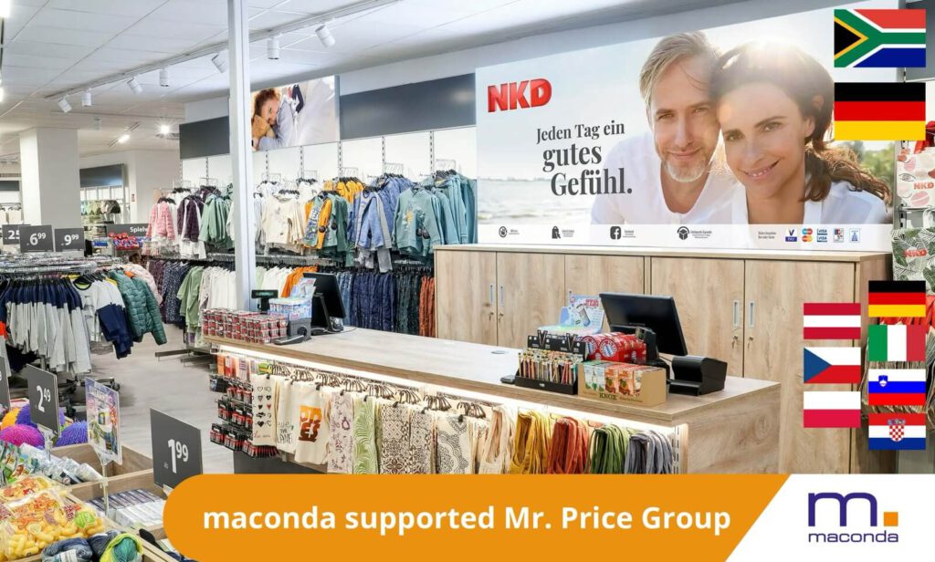 Interior view of a clothing store with jacket racks a long checkout counter and a large NKD banner colourful national flags on the right hand wall