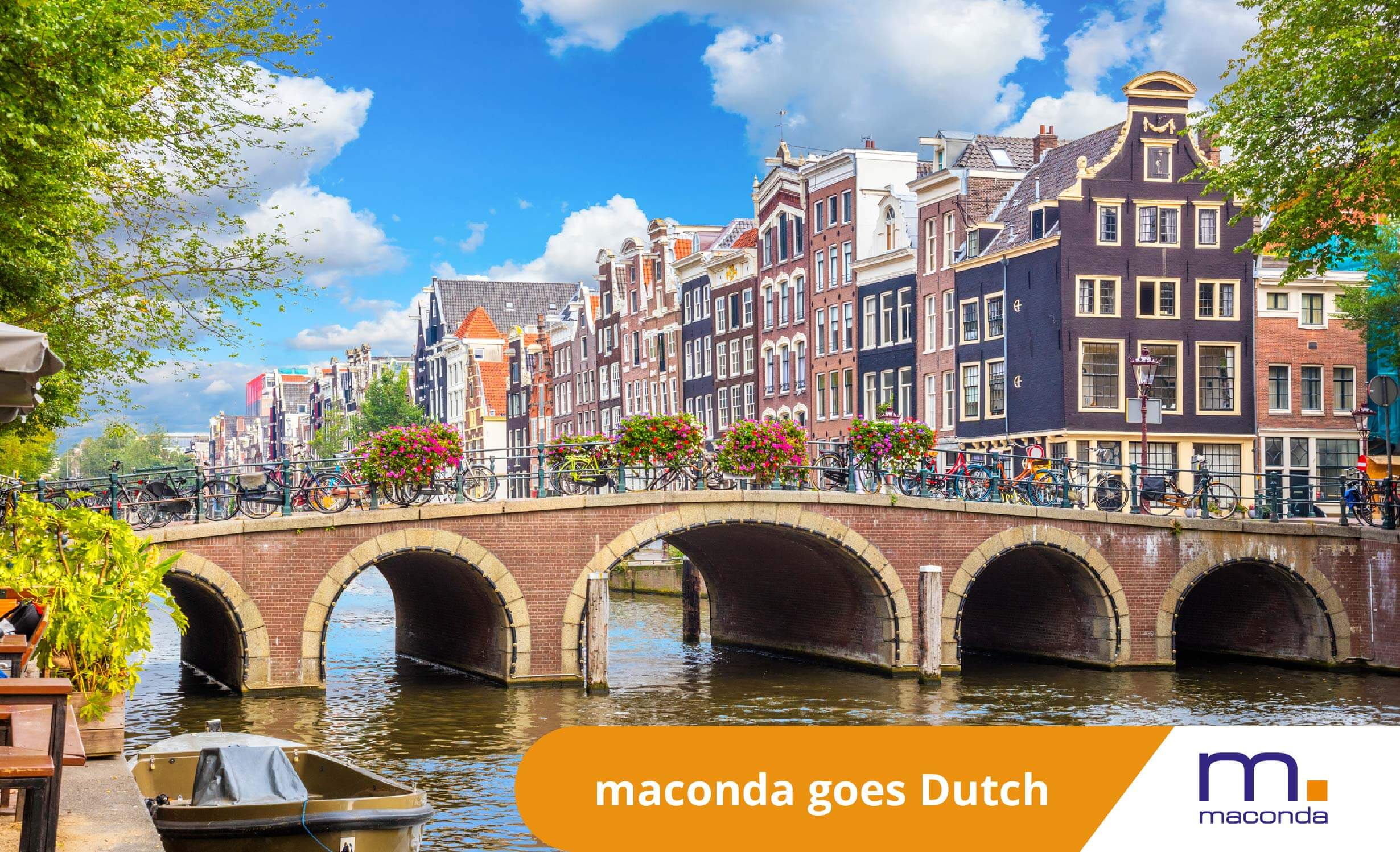 maconda Newsletter - Dealbanner Dutch 260115 - maconda Historic canal houses on a brick bridge in Amsterdam bicycles on the railing under a blue sky banner with maconda goes Dutch