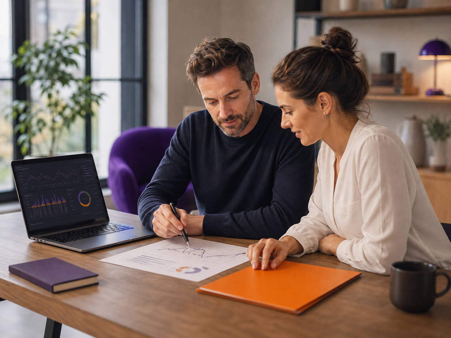 maconda-liquiditaetsmanagement - maconda Zwei Fachleute prüfen Finanzdiagramme an einem Holzschreibtisch der Laptop zeigt Grafiken in einem hellen Büro