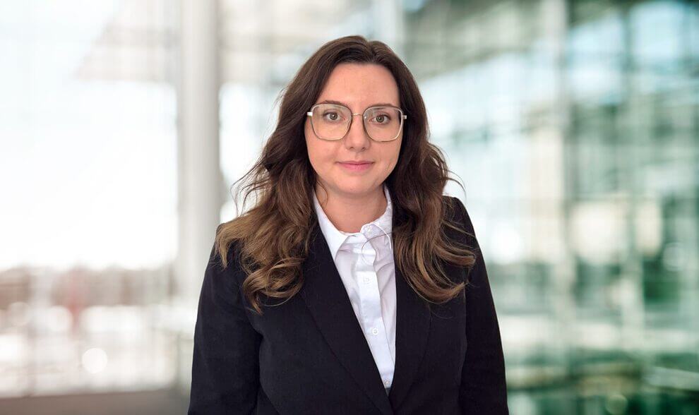 Porträt von Lisa Lopatowski maconda mit Brille in schwarzem Blazer und weißem Hemd in einem hellen Büro